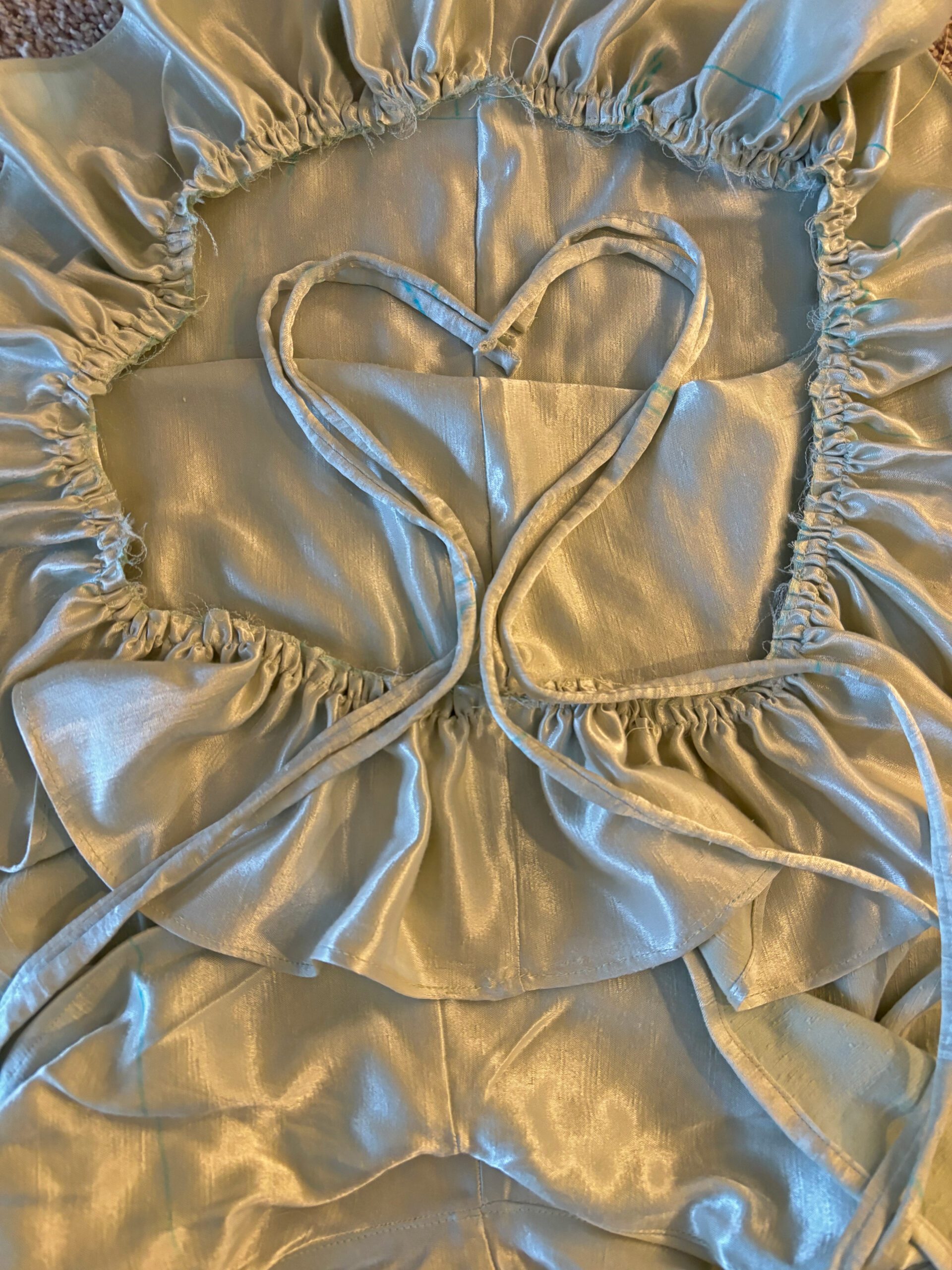 Close up look of the unfinished garment with different lighting hitting different surfaces of the fabric, creating a mesmerizing shimmer.