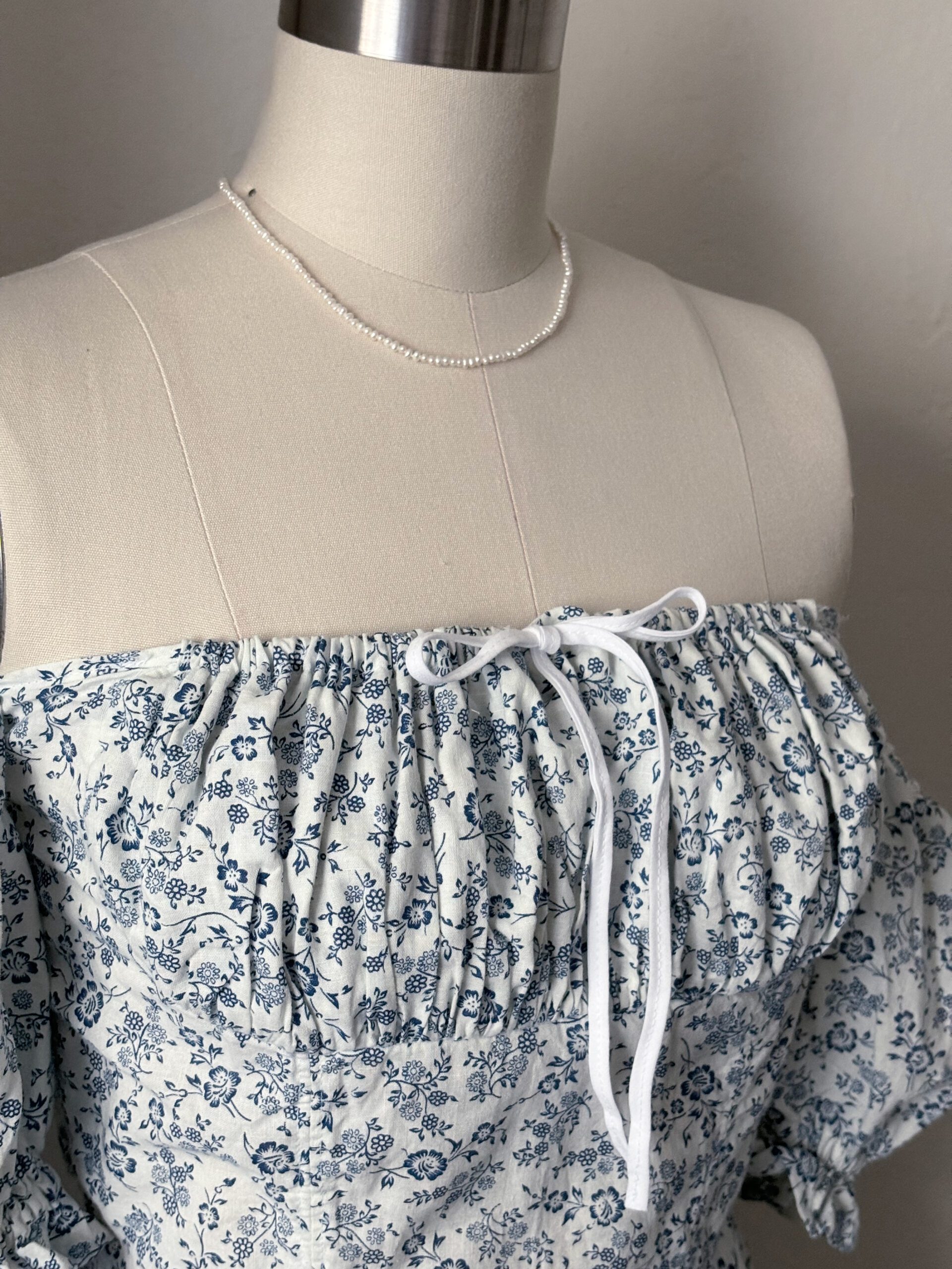 A close up look of the gathered bust with a bow knot on the front bodice.