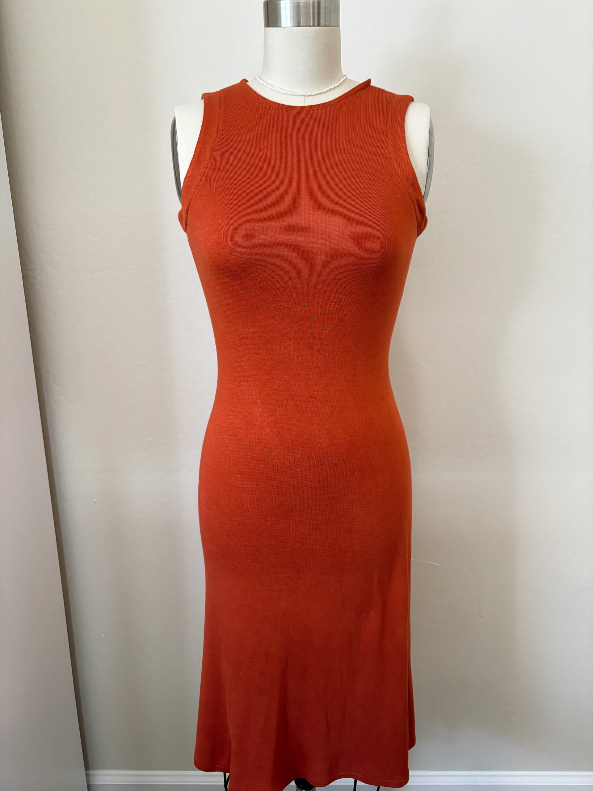 A full view of the modified Nikko dress by True Bias in burnt orange knit fabric, showcasing the flared bottom, cinched waist and racerback style top.