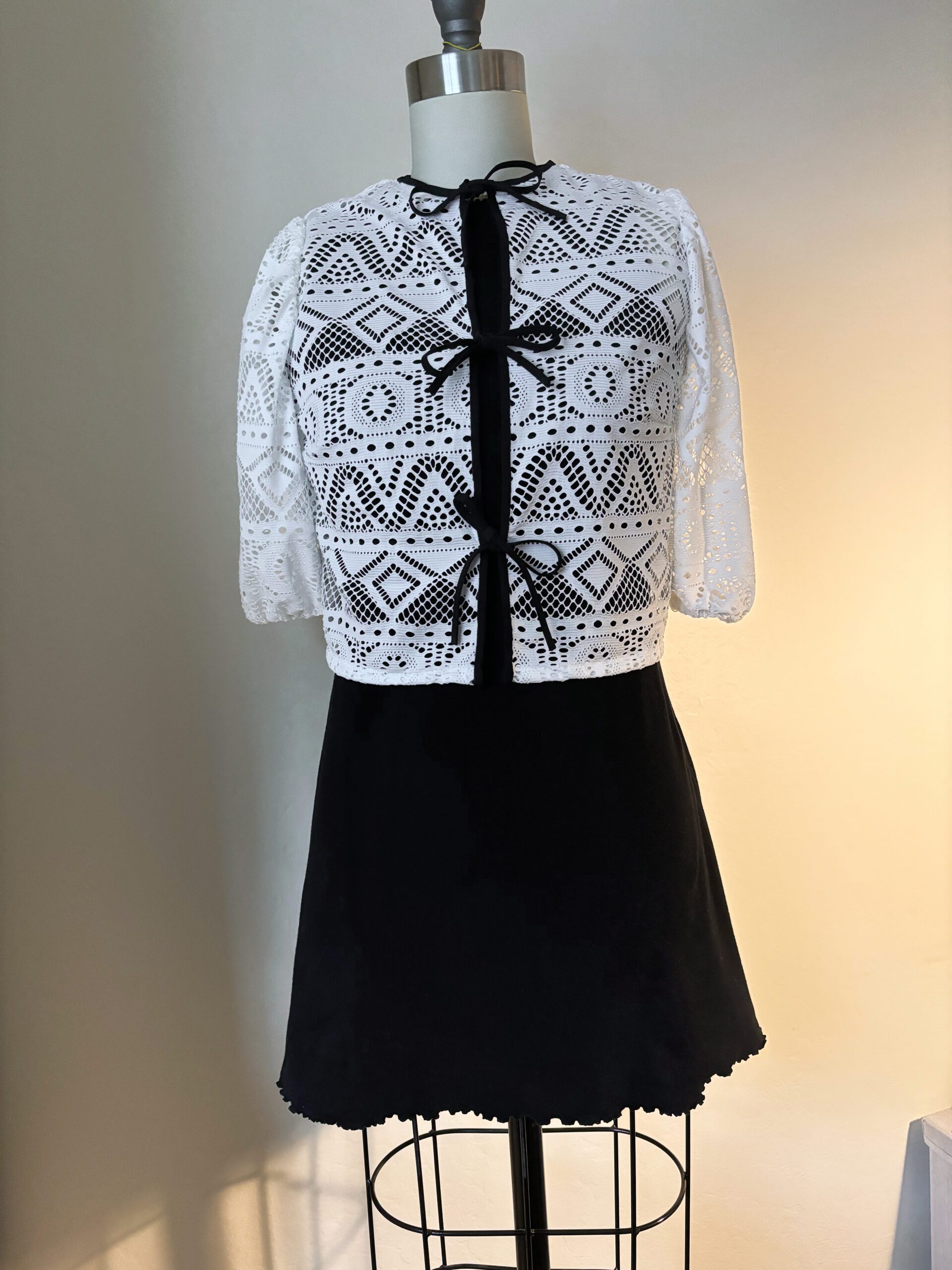 The little black dress is styled with a handmade lace knit cardigan.