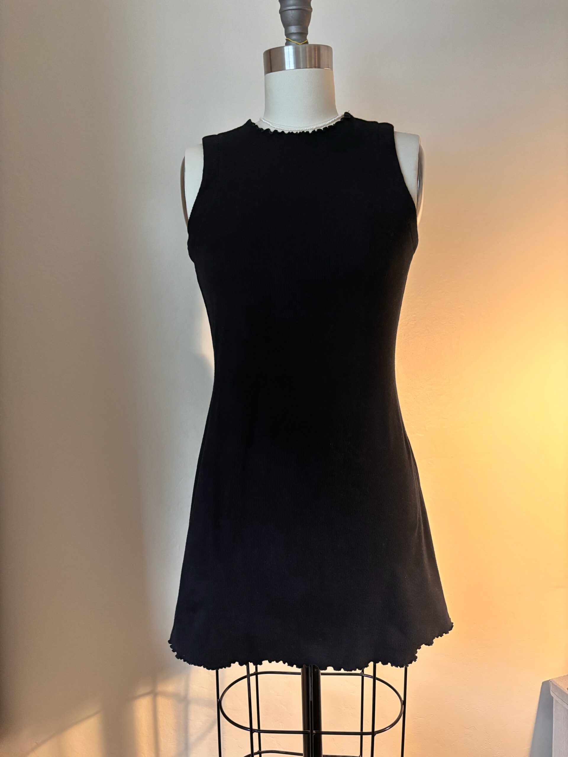 A full view of the little black dress with lettuce edge details.