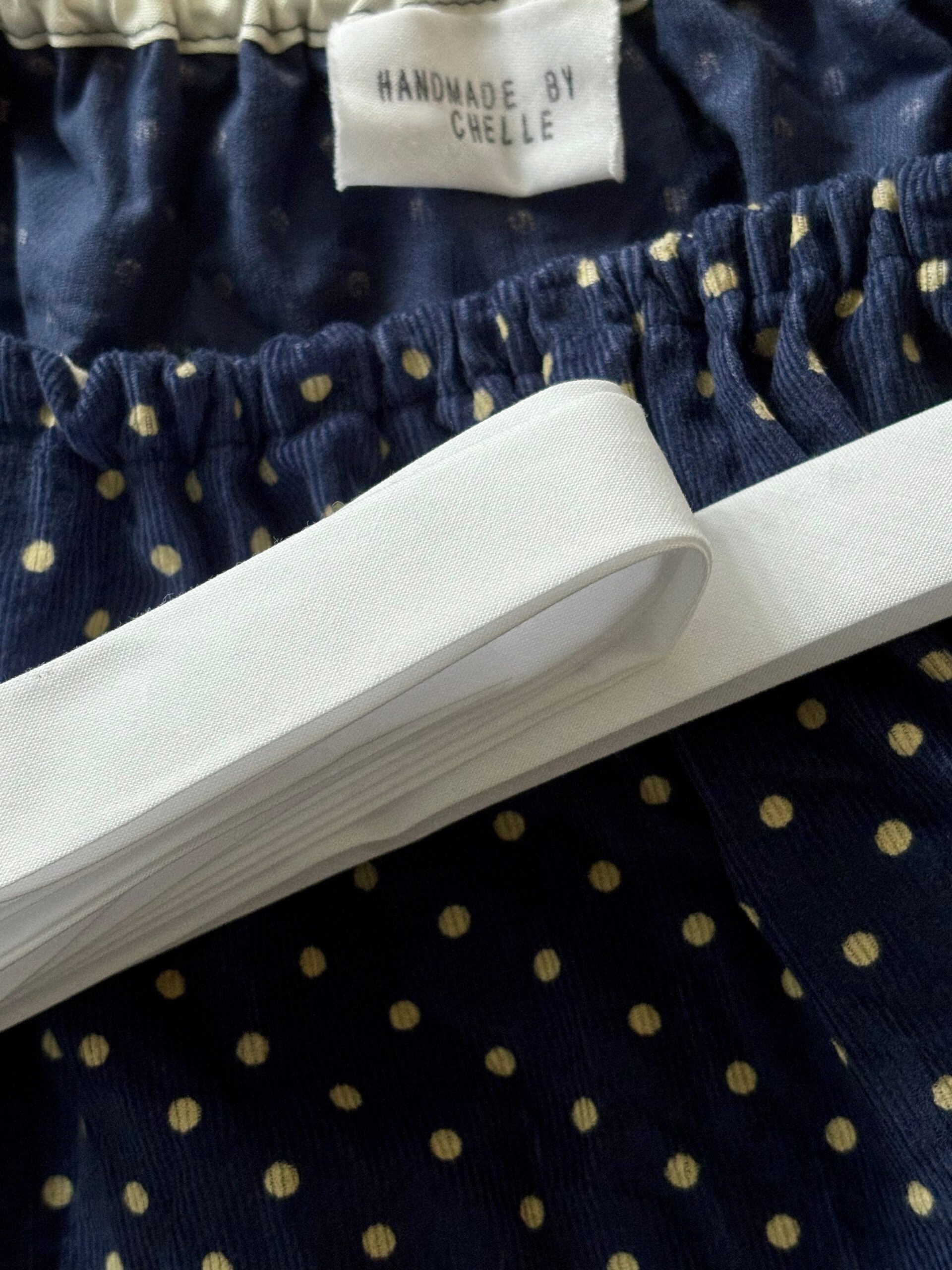 A roll of white bias tape that can be used to make DIY or handmade clothing label.