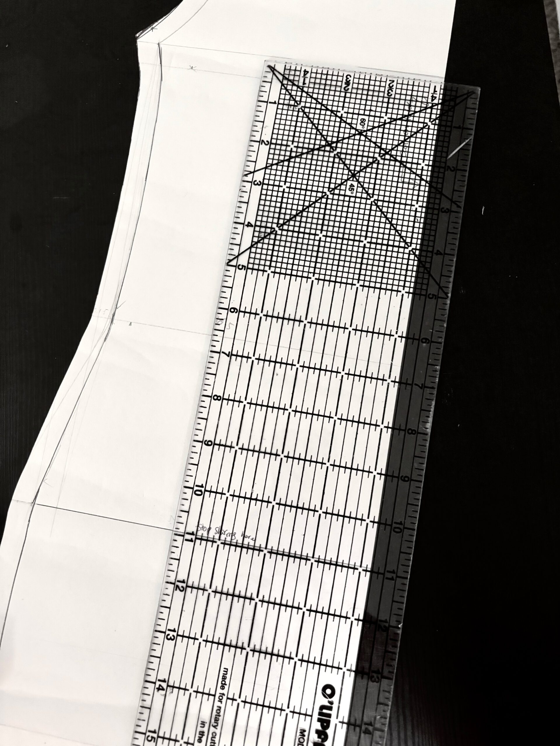 A long sewing or quilting ruler with gridline that is useful for measuring and making precise cuts through fabric.