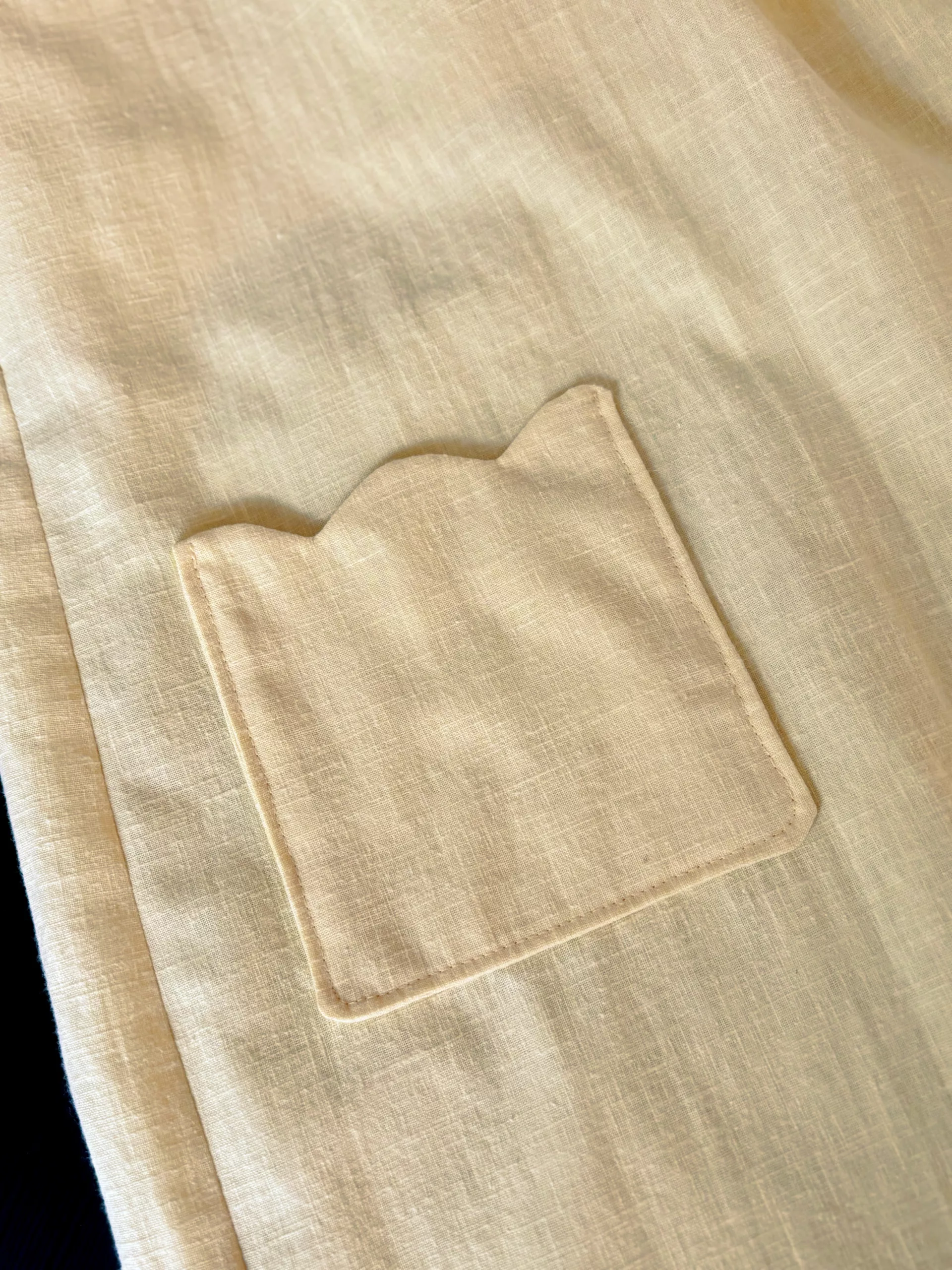 A close up view of the scalloped patch pocket.