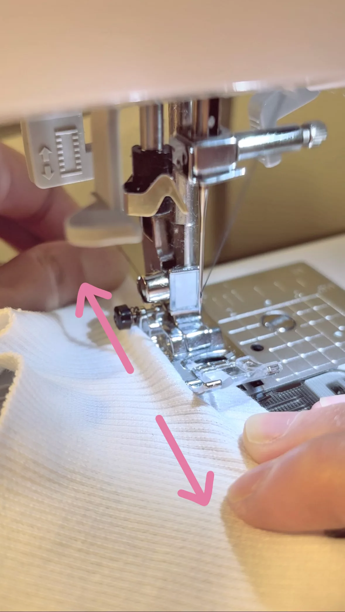 Close-up of sewing a lettuce hem: stretch the fabric while guiding its movement with both hands.