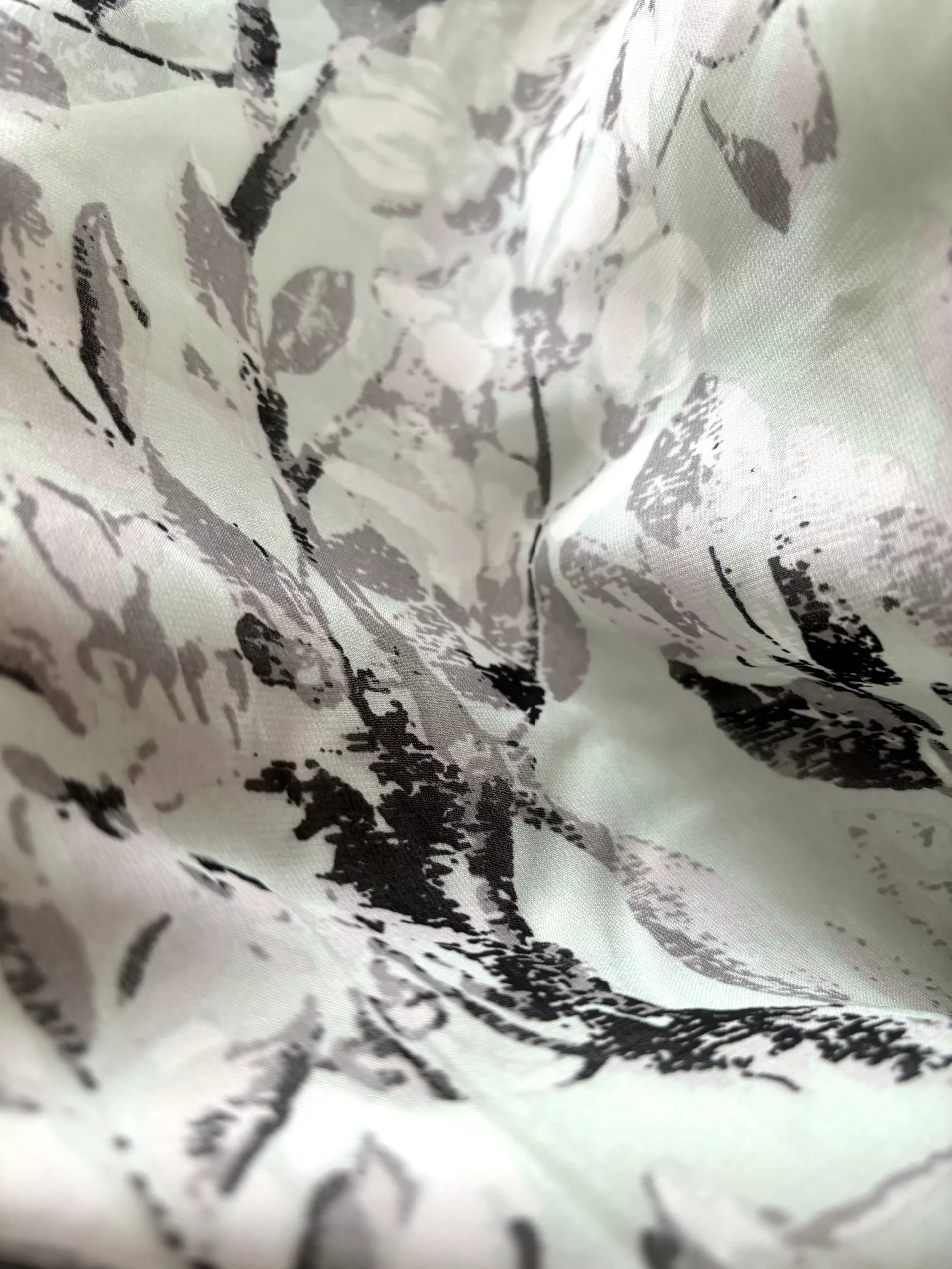 A close-up of the mint-colored main fabric adorned with black and white floral prints.